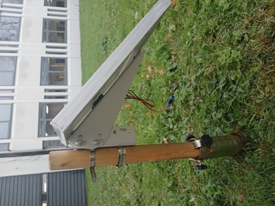 Solar panel on wooden pole in soil spike